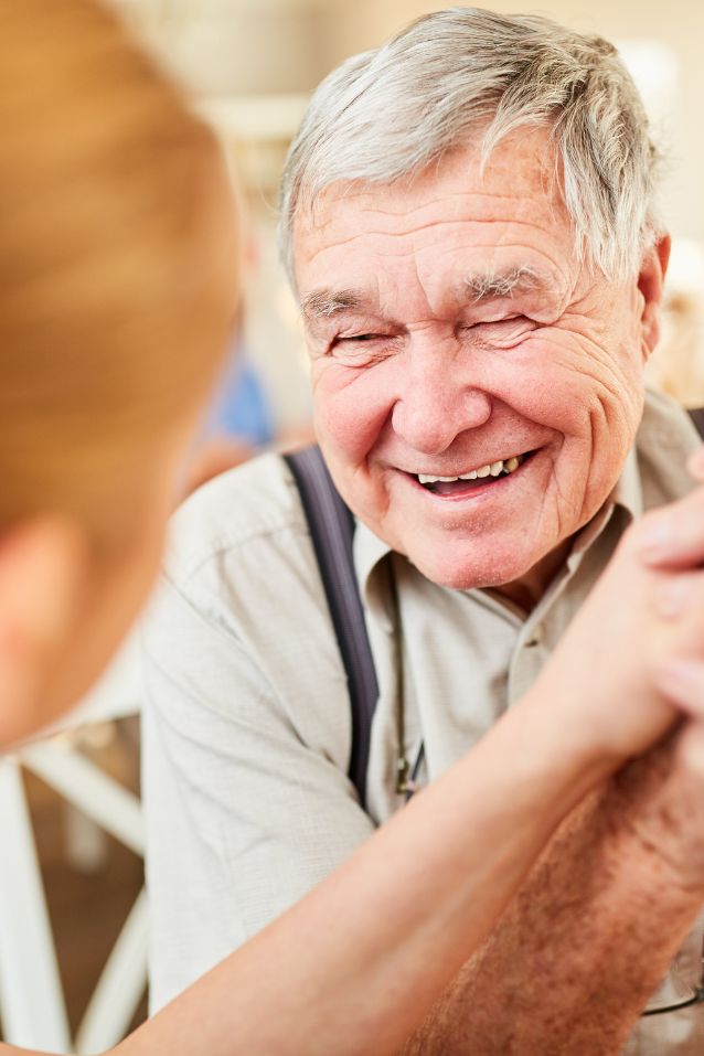 elderly-man-smiling respite caregiver providing assistance