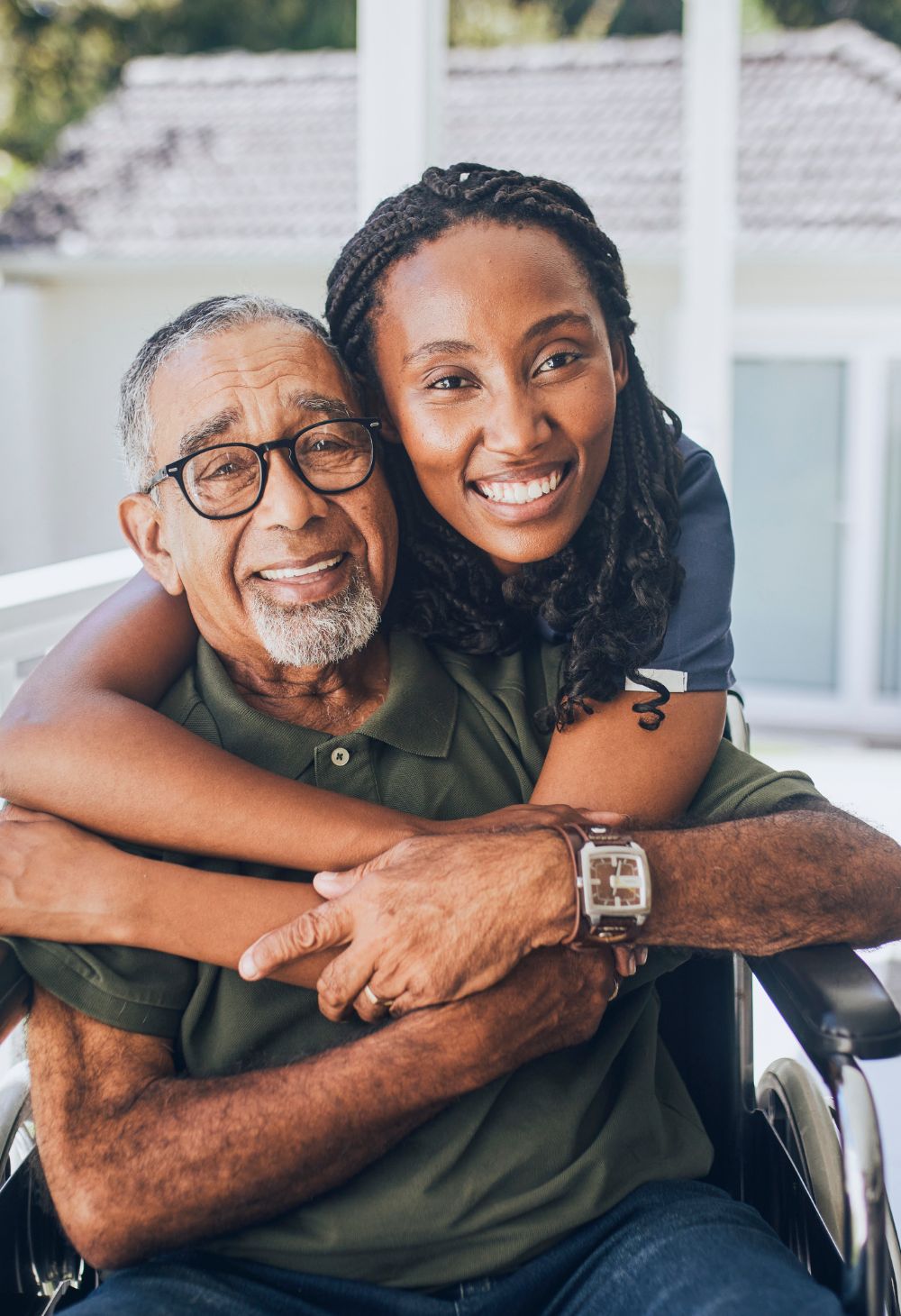 caregiver hugging senior man A caregiver hugging a senior man sitting on a wheelchair from behind.