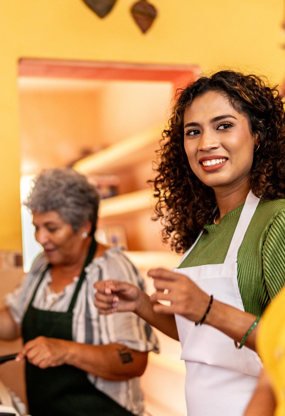 A caregiver preparing food with a senior woman during a cooking activity.