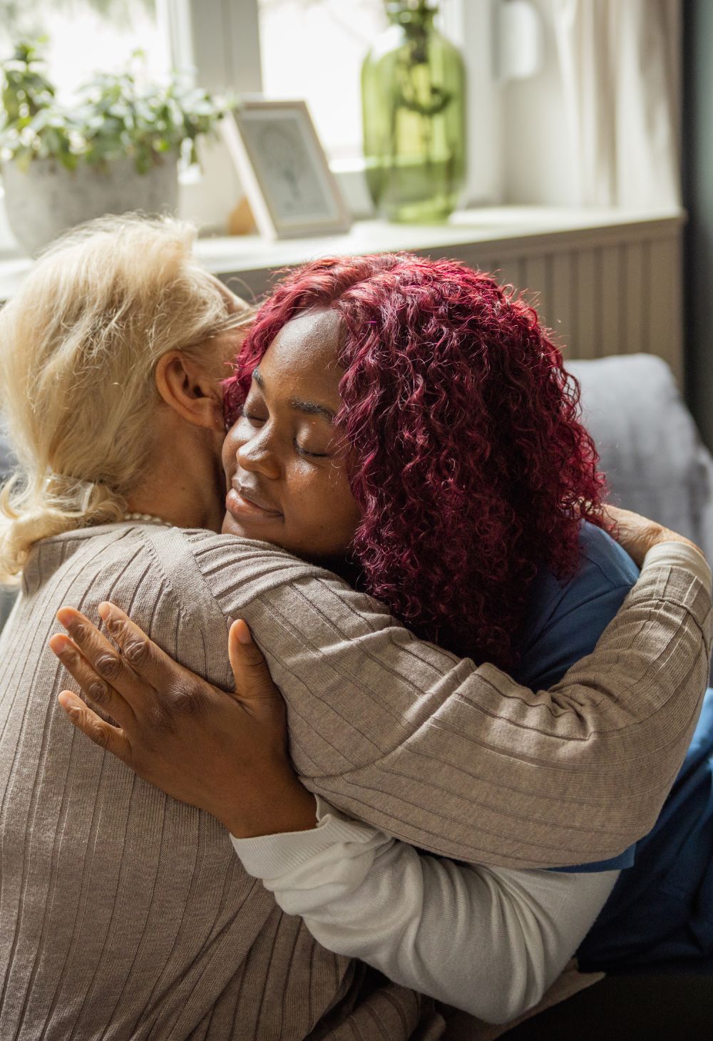Caregiver embracing an elderly woman, providing emotional support during in-home care